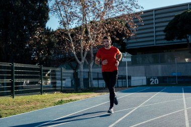 Stadyumda koşan atletik bir adam