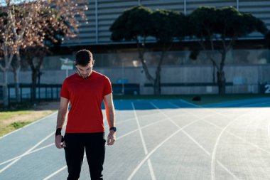 Genç adam koşuyor ve geriniyor.
