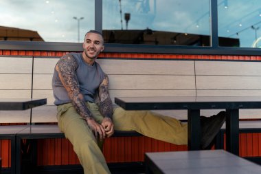 Kafedeki masada oturan yakışıklı genç adam..