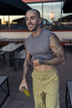 Parkta dövmeleri olan yakışıklı bir genç.