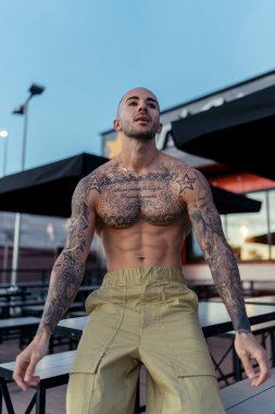 Şehirde dövmeleri olan genç yakışıklı bir adam.