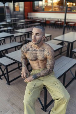 Kafede dövmesi olan yakışıklı bir genç..