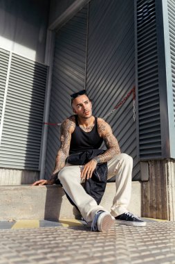 Yerde oturan bir adamın portresi.