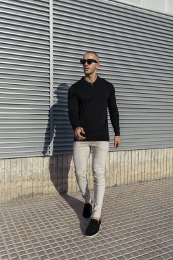 Sokakta siyah elbiseli yakışıklı sakallı adamın portresi.