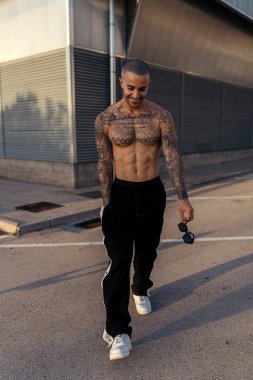 Kaslı gövdesi olan yakışıklı genç adam egzersiz yapıyor.