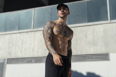 Şapkalı genç yakışıklı kaslı atlet