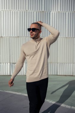 Şık giyinmiş genç adam sokakta yürüyor.