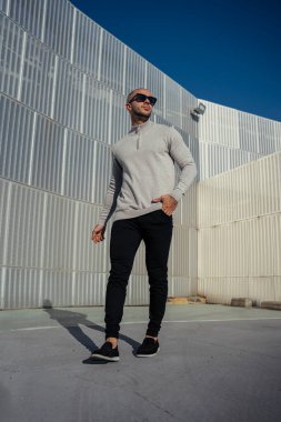 Dışarıda poz veren güneş gözlüklü yakışıklı bir adamın portresi..