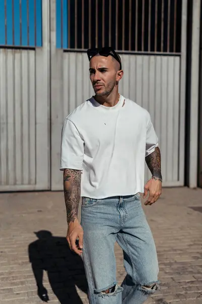 Genç ve çekici bir adam şehirde kameraya poz veriyor..