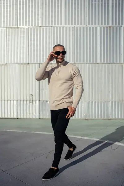 Sokakta poz veren günlük kıyafetli genç adam.