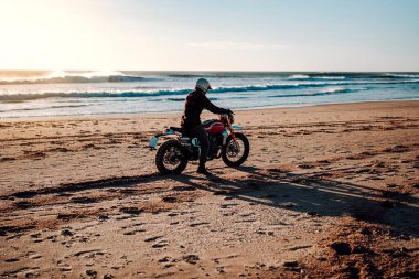 Günbatımında motosiklete binen adam.