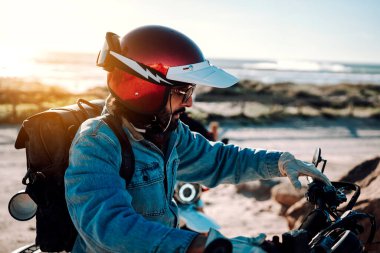 Kasklı ve motosikletli bir çocuk.