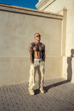 Şehirde bir sokakta güneş gözlüklü genç bir adamın portresi..