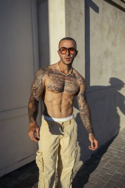 Sabahları sokakta beyaz tişörtlü ve gözlüklü yakışıklı bir adam.