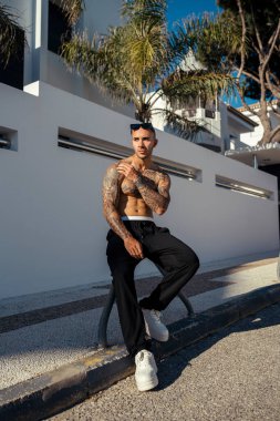 Şehirde dövmesi olan yakışıklı bir adam.