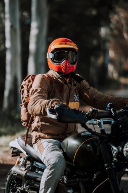 Ormanda motosikletli bir motorcu, seçici bir odak noktası.