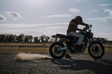 Siyah kasklı ve motosikletli genç bir kız.