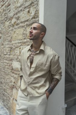 Genç adam merdivenlerde dikilip kameraya bakıyor.