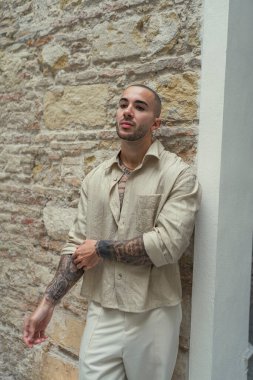 Genç, yakışıklı, sakallı hippi şık kıyafetler giymiş, dövmeli, şehir sokaklarında klasik tarzda poz veren, yaşam tarzı konsepti olan biri.