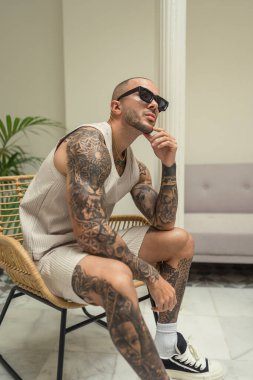 Stüdyoda dövmeli genç bir adam var.