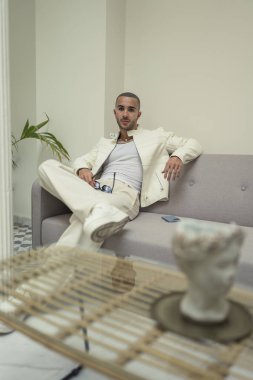 Beyaz takım elbiseli yakışıklı bir adamın portresi ve beyaz gömlekli bir fincan çay..