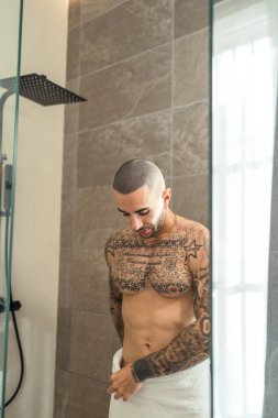 Genç adam banyoda duruyor.
