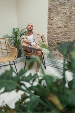 Yakışıklı sakallı adam masada oturuyor.