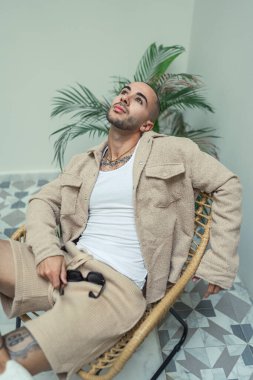 Bej takım elbiseli yakışıklı, sakallı bir adamın portresi.