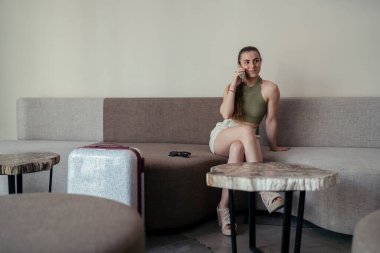 Genç bir kadın oturma odasında oturmuş müzik dinliyor.