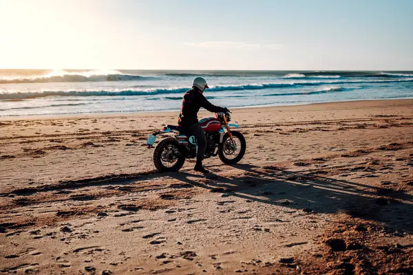 Günbatımında motosiklete binen adam.