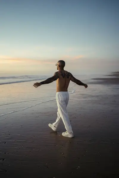 Adam sabahları plajda yoga yapıyor.