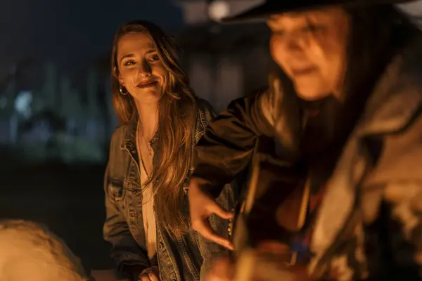 Kovboy şapkası takmış genç ve güzel bir kadın ve gece mumlarla dolu ekose bir gömlek.