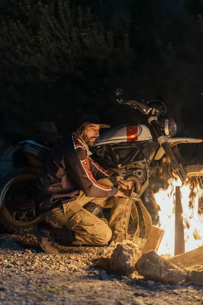 Ekoseli genç bir adamın arka planda bir ateşle dikey görüntüsü.