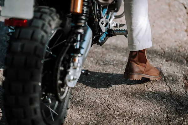 Siyah deri kasklı genç adam ve siyah ceketli beyaz bisikletli.