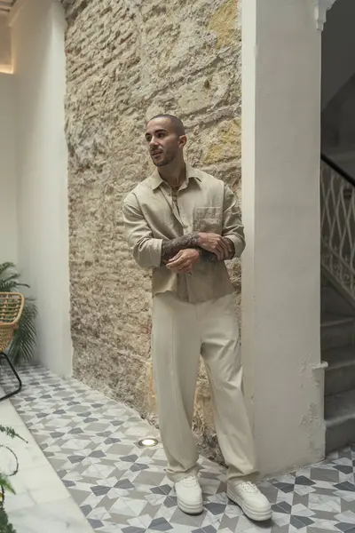 Otelin içinde şık giyinmiş genç bir erkek.