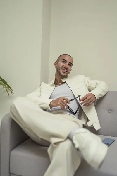 Takım elbiseli Afro-Amerikan işadamı kanepede oturuyor.