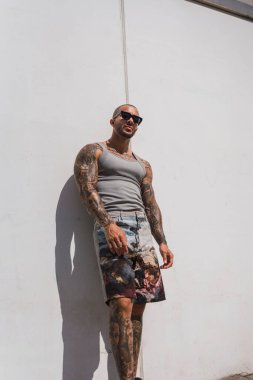 Beyaz tişörtlü ve şortlu yakışıklı bir gencin portresi..