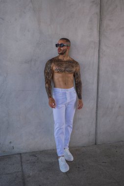 Beyaz güneş gözlüklü ve beyaz gömlekli yakışıklı bir adam portresi.