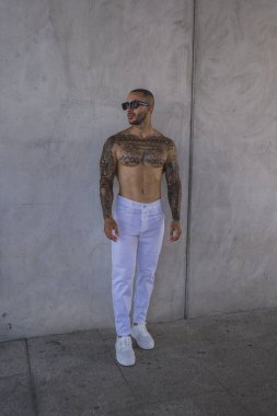 Beyaz gömlekli ve güneş gözlüklü yakışıklı genç adam.