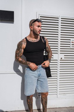 Şehirde dövmeleri olan yakışıklı bir adam.