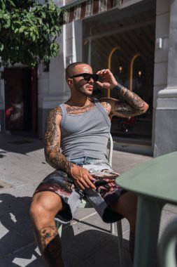 Adam masada kahve içiyor.