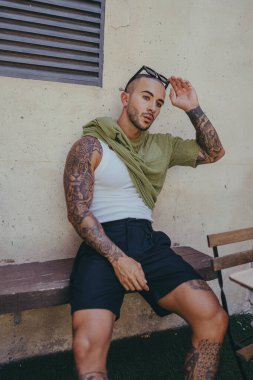 Genç yakışıklı adam şehirde poz veriyor.