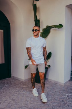 Beyaz tişörtlü yakışıklı bir adam.