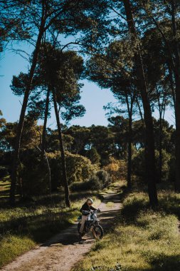 Sırt çantalı bir adam parkta yolda.