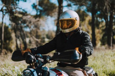 Ormanın ortasında motosiklet süren bir adam.