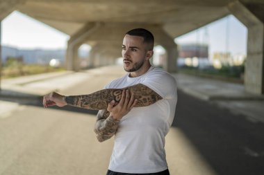 Genç adam sokakta geriniyor, yolda koşuyor..