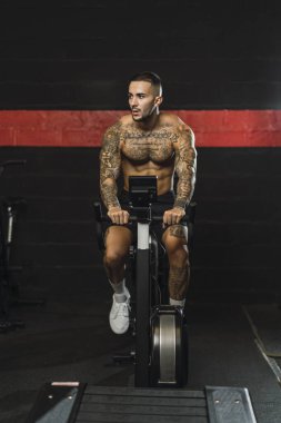 Dövme makinesi olan adam spor salonunda.