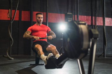 Yakışıklı kaslı adam spor salonunda çalışıyor..