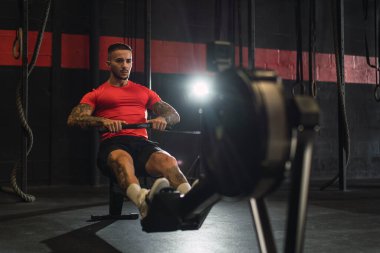 Yakışıklı kaslı genç adam spor salonunda antrenman yapıyor.