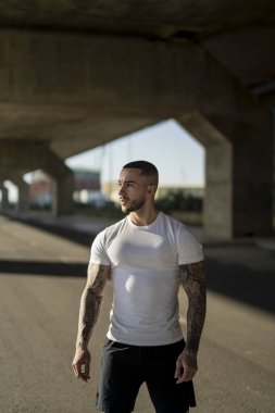 Beyaz gömlekli genç yakışıklı adam poz veriyor.